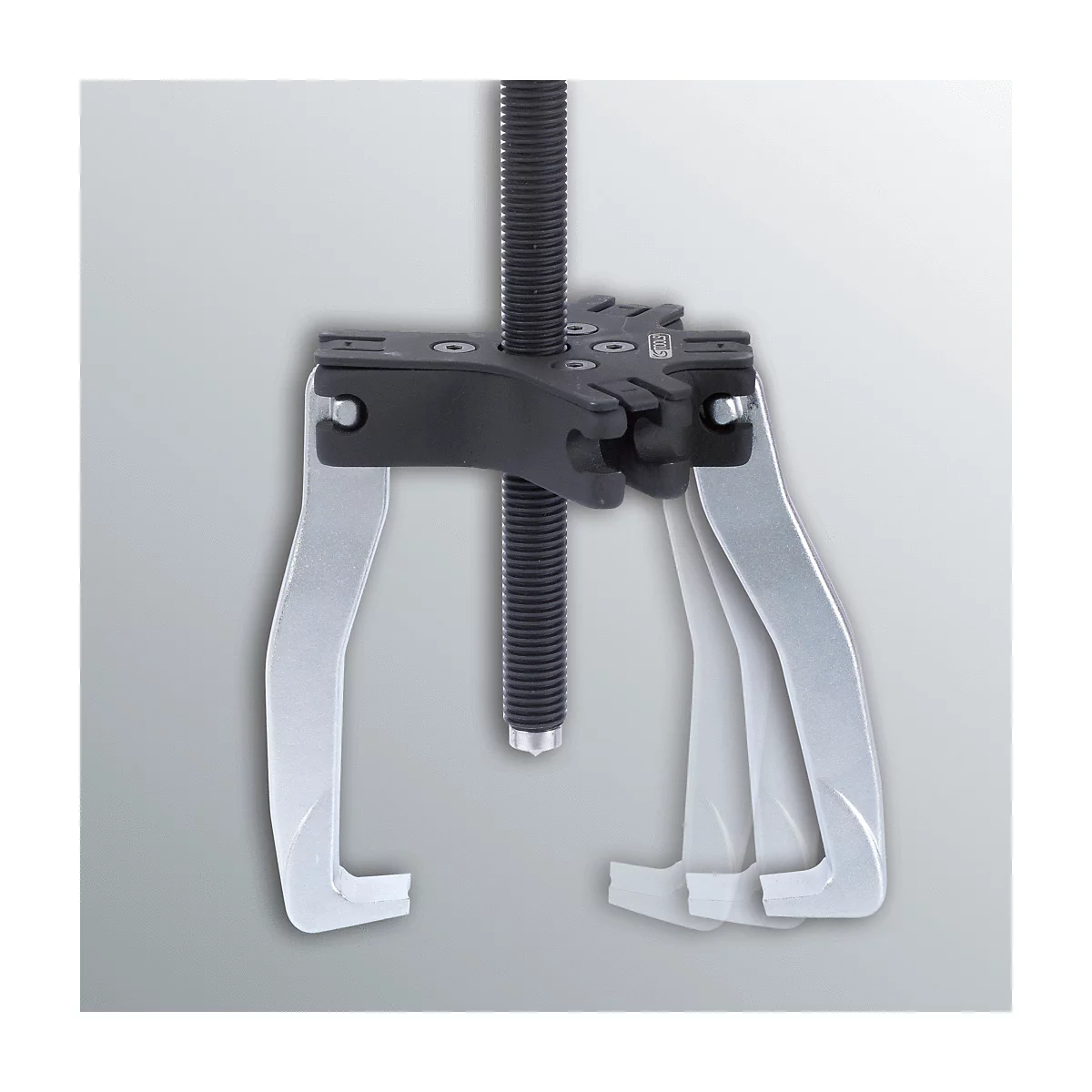 Ein silberner Abzieher mit drei Armen und einer schwarzen Schraube, vor grauem Hintergrund.